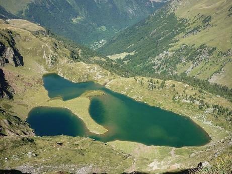 En contrebas du sentier taillé dans la falaise, le lac Vert