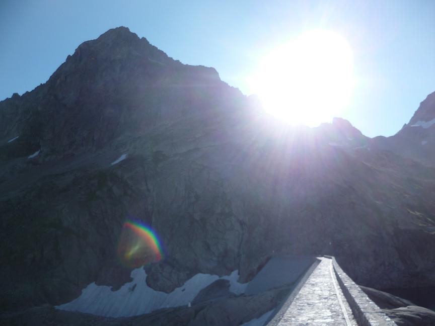 Traversée du barrage du lac du Portillon, face au pic Lézat et au soleil